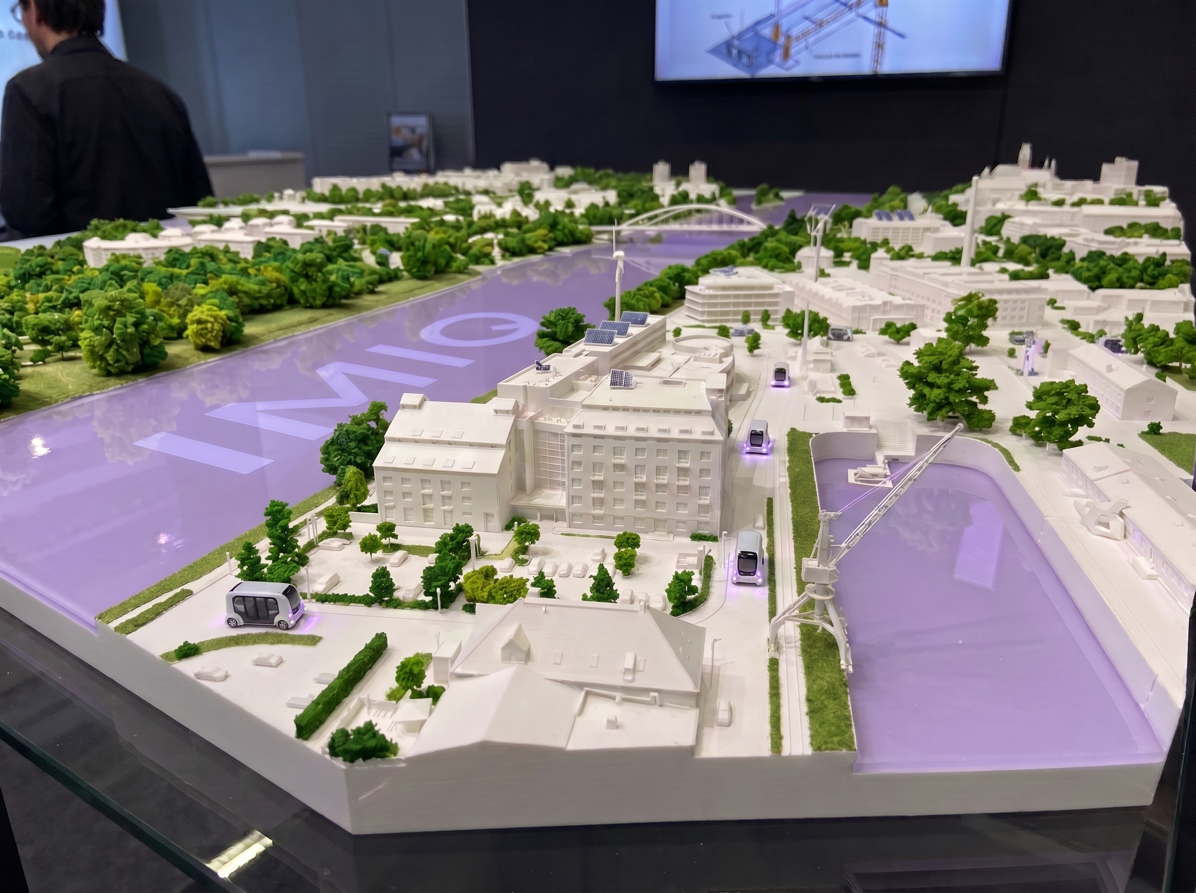 Modell einer intelligenten Stadt mit Fluss, autonomen Fahrzeugen und grüner Infrastruktur